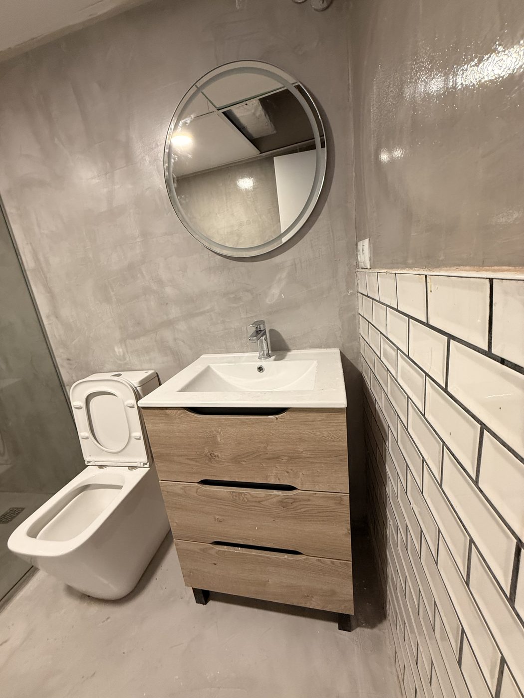 Reforma de baño con alicatado metro blanco y mueble suspendido